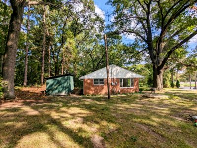 The house from the side lawn under mature trees