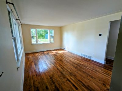 Bedroom with hardwood floors and two windows