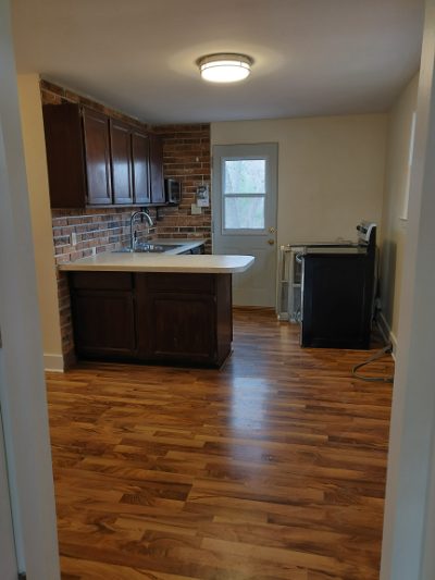 Kitchen with peninsula, dark cabinets and brick backsplash